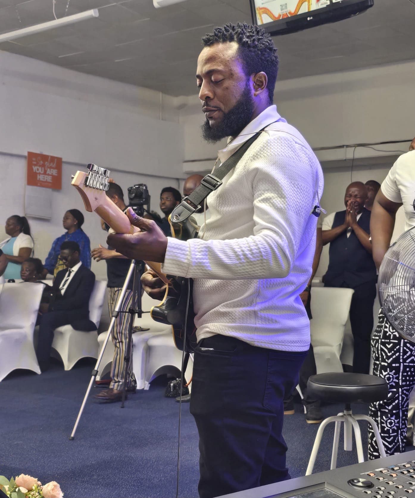 Ogunlowo Daniel Segun playing guitar during a live worship service